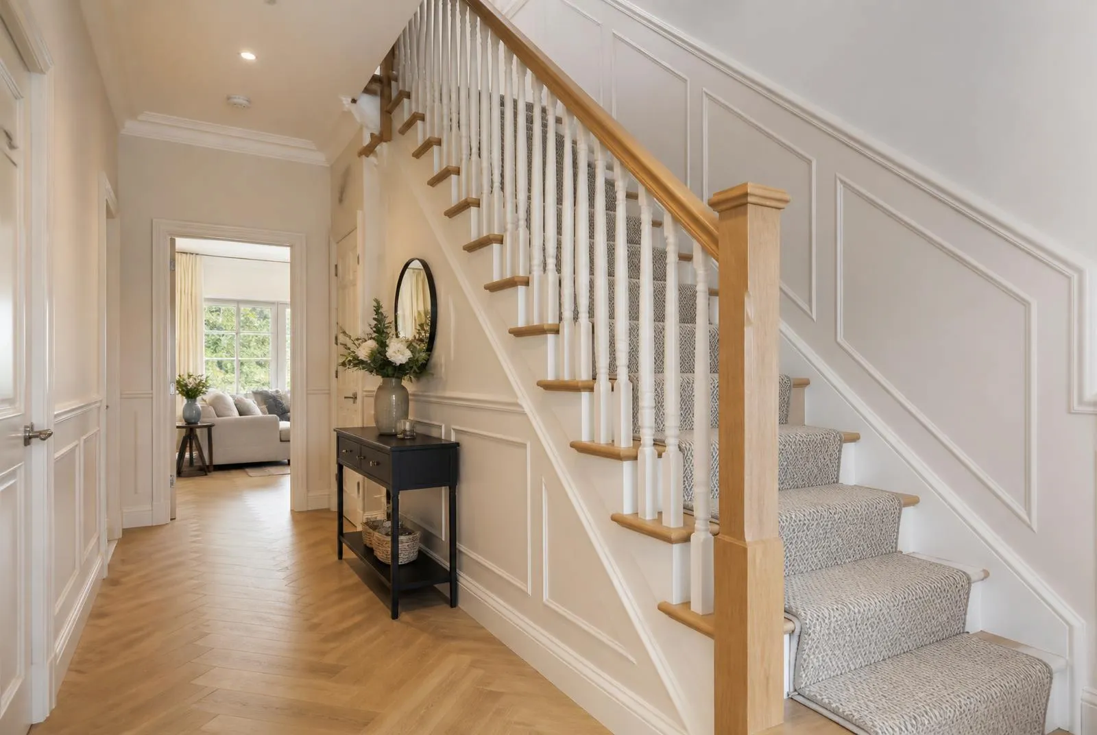 Refurbished staircase with white spindles, timber handrail and a neutral runner carpet