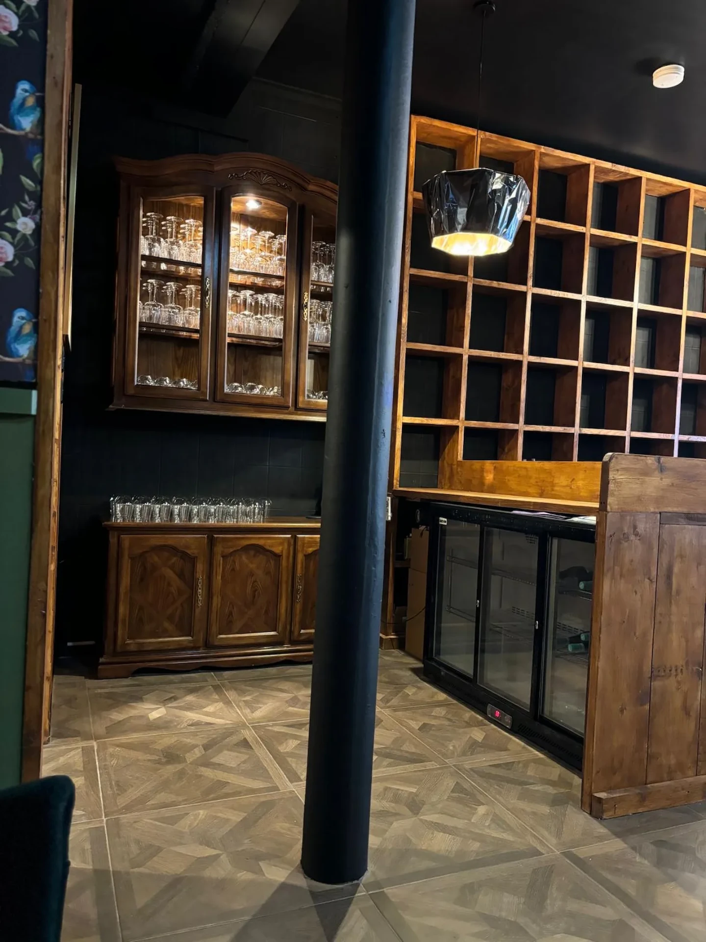 Area behind the bar with glass storage and bespoke shelving