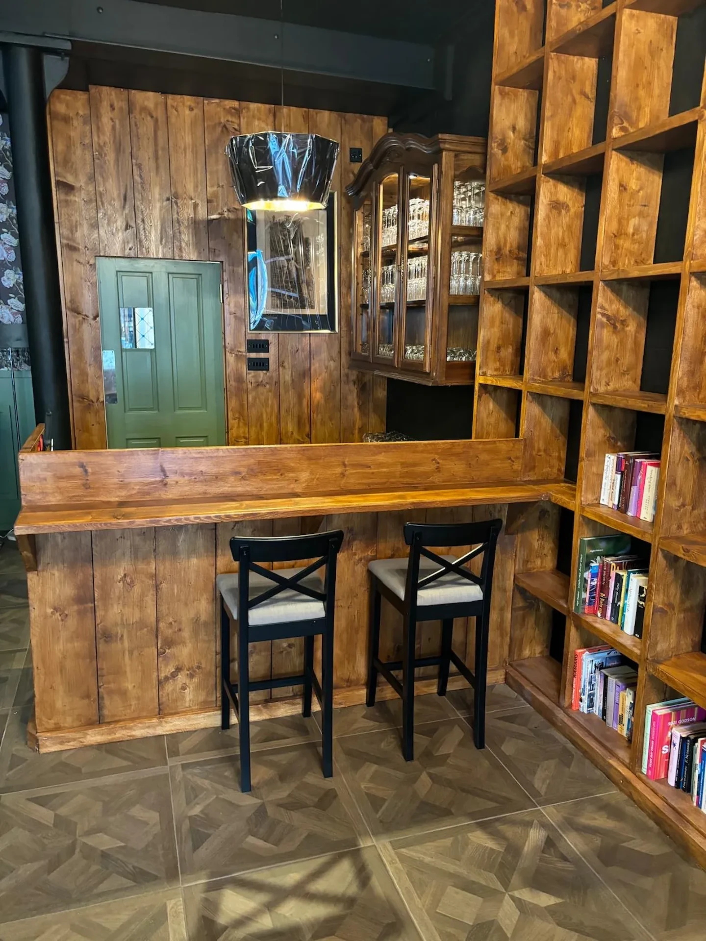 Timber-panelled bar and reception counter with tall stools