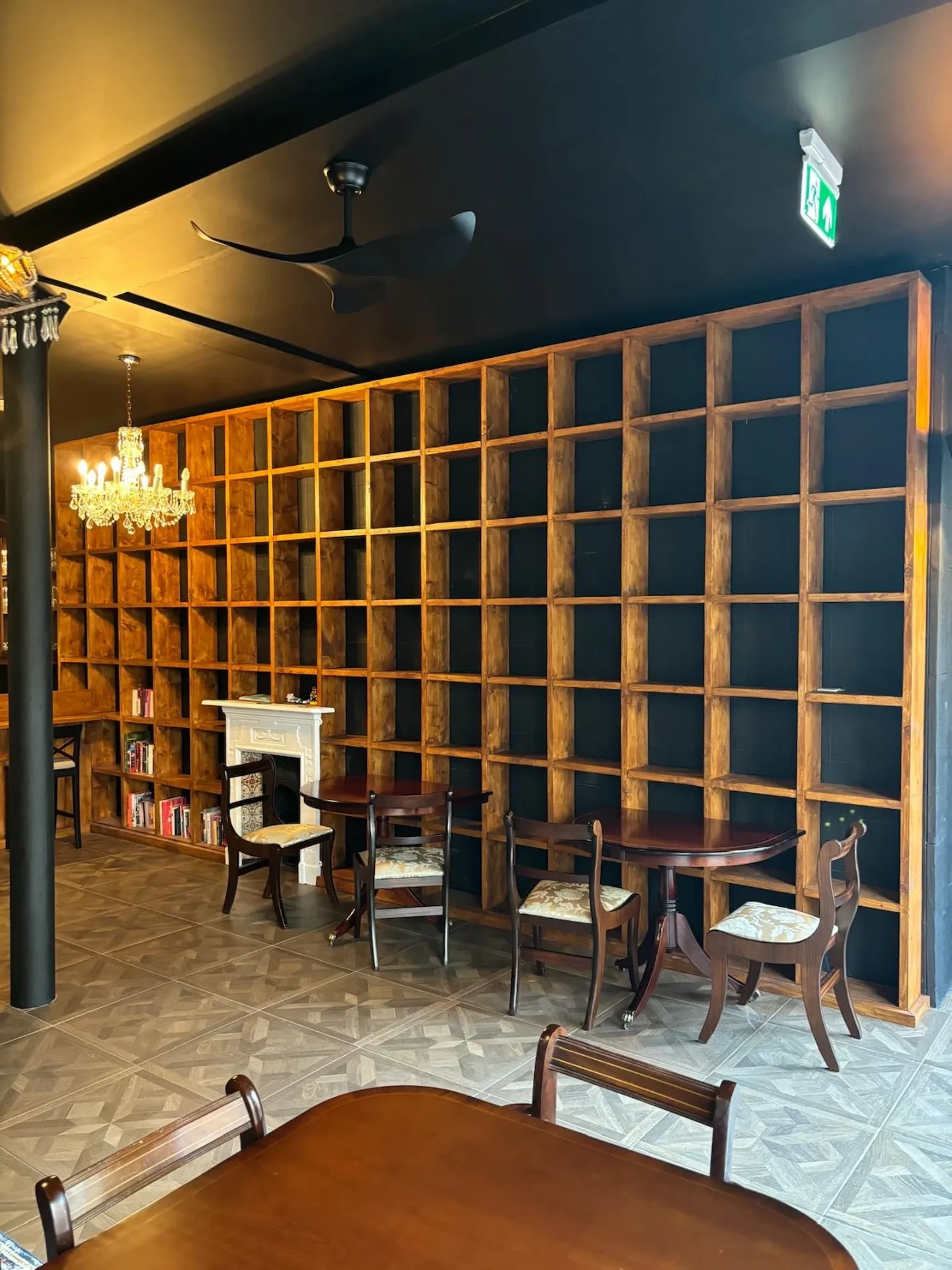 Full-height bespoke timber grid shelving covering the restaurant wall